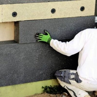 Construction workers insulating house facade